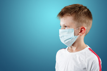 Little boy, a child in a medical mask on a blue background. The concept of an epidemic, influenza, protection from disease, vaccination.