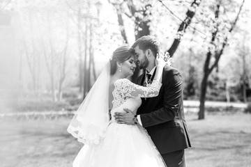 Naklejka premium young and beautiful bride and groom enjoy each other. wedding couple enjoying romantic moments outside.