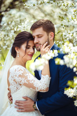 Obraz premium young and beautiful bride and groom enjoy each other. wedding couple enjoying romantic moments outside.