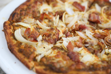 Pizza with crispy bacon onion on outdoor table