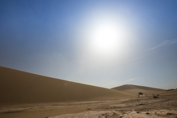 Fototapeta premium Tourists ride Camel over Sunshine Summer Desert