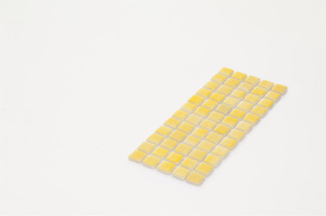little yellow ceramic tile on a white background, majolica. for the catalog