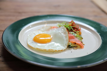 Zucchini fritters with egg and smoked salmon on wood background vinage style