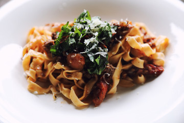 Pasta Fettuccine Bolognese with beef and tomato sauce on wood background in dark tone mystic light style