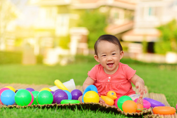 Obraz premium Cute Asian baby playing with toys and smile in playground 