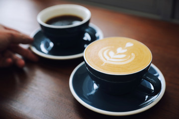 cappuccino or Latte art coffee made from milk on the wood table in coffee shop