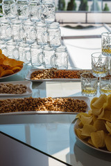 peanuts and chips on a buffet with alcoholic beverages.