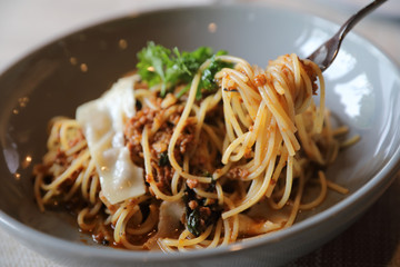 spaghetti Bolognese with minced beef and tomato sauce garnished with parmesan cheese and basil , Italian food