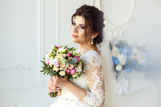 Beautiful bride with fashion wedding hairstyle - on white background Wedding. Studio shoot.Beautiful bride with bouquet of flowers