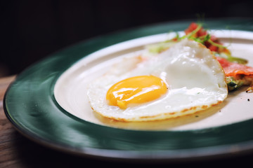 Zucchini fritters with egg and smoked salmon on wood background vinage style