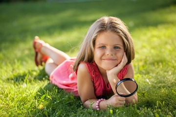 Portrait of a Little Girl Looking Grass with Magnifying Glass