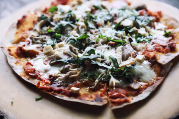 Pizza with  ham tomatoes mozzarella cheese and basil. Delicious italian pizza on wooden pizza board