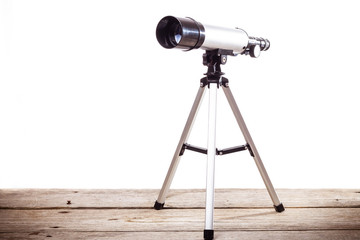 telescope on a white background laid on wooden board