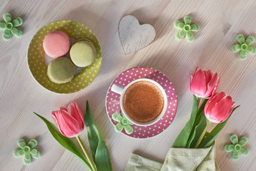 Obraz na płótnie Canvas Spring coffee background. Macarons, espresso in pink cup, freesias and pink tulips
