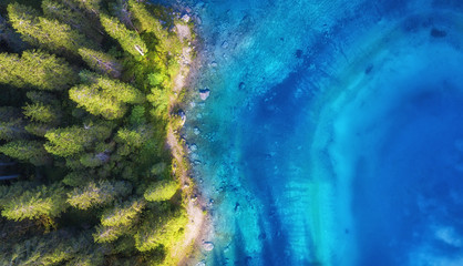 Aerial view on the lake and forest. Natural landscape from drone. Aerial landscape from air in the Dolomite alps, Italy.