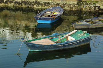 Fototapeta na wymiar Three old wooden rowing boats on a pier