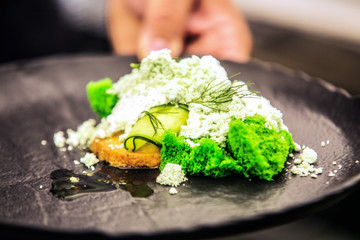 Modern food stylist decorating meal for presentation in restaurant. Closeup of food stylish. Restaurant serving