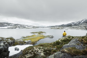 Typical norwegian landscape with snowy mountains and clear lake near the Trolltunga rock - most spectacular and famous scenic cliff in Norway