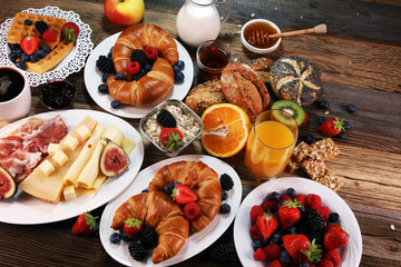 breakfast on table with waffles, croissants, coffe and juice.