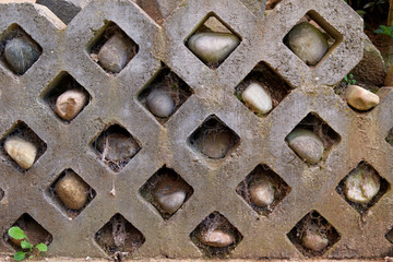 Stone wall with rocks in holes and spiderwebs - Garden