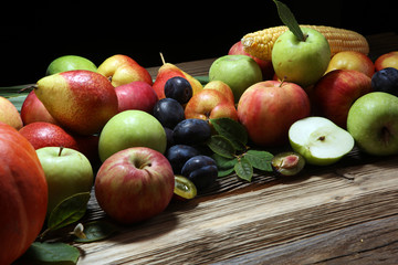 Various fresh fruits. Thanksgiving pumpkin, apples, and maize on rustic background.
