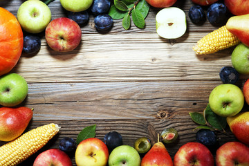 Various fresh fruits. Thanksgiving pumpkin, apples, and maize on rustic background.