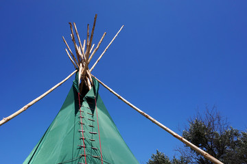 Top of Indian wigwam lodge or teepee against blue sky background. travel concept. copyspace © MichaelPervak