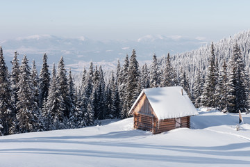 Fantastic winter landscape with wooden house in snowy mountains. Christmas holiday concept. Carpathians mountain, Ukraine, Europe