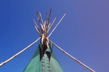 Top of Indian wigwam lodge or teepee against blue sky background. travel concept. copyspace © MichaelPervak