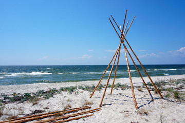 Foundation for Indian wigwam lodge or teepee made of pine wood at the seashore at summer. travel concept. copyspace © MichaelPervak