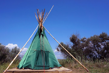 Indian wigwam lodge or teepee between trees and plants. travel concept. copyspace © MichaelPervak