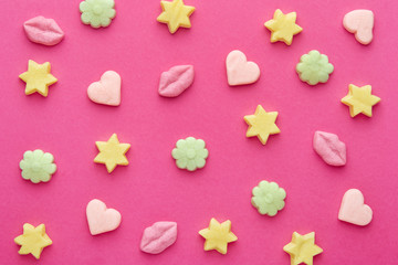 Candies pattern on a pink background viewed from above. Repetition concept. Top view. Flat lay