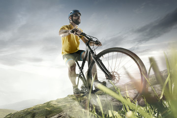 The young fit men in helmet conquering mountains on a bicycle. The bike, nature, bicycle, sport,...