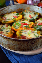 Bell peppers stuffed with vegetables and cheese with tomato sauce in a frying pan