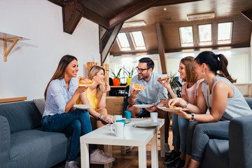 Quality time with friends. People talking to each other and eating pizza at home.