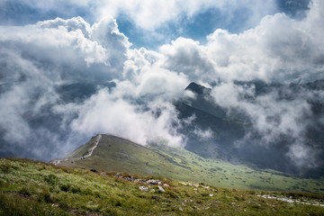 Scenic mountain view with dramatic low clouds at summer day in Tatra mountains, Poland