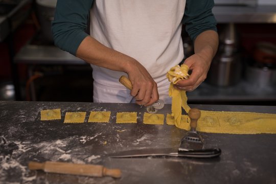 Male baker preparing pasta in bakery