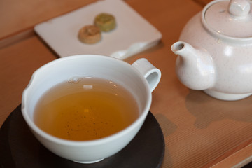 Close-up of Tea in a Cup, Tea Pot and Small Snacks