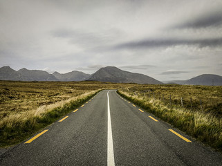 Road view of mountains, hills and fields, taken along the Wild Atlantic Way in Western Ireland in summer