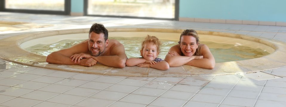 Glueckliche Familie mit Tochter im Whirlpool beim Baden