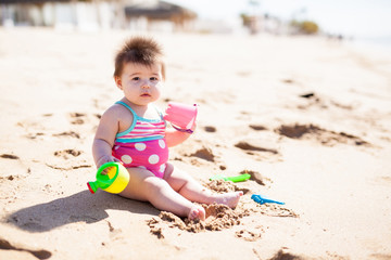 Baby girl playing in the beach sand