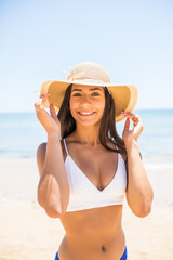 Closeup Of Smiling Beautiful Young Woman At Beach With Straw Hat on the sea beach