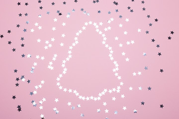 Obraz na płótnie Canvas Pink background with silver star confetti. Top view.