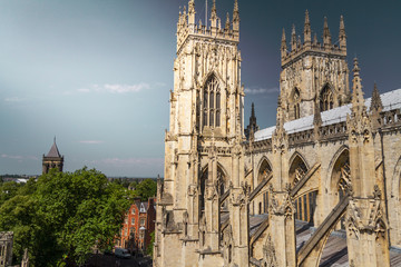 Fototapeta na wymiar Beautiful sunlit view of the spires of York Minster Cathedral with the town in sight in Yorkshire, England UK.