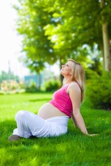 Naklejka na ściany i meble Portrait of a Pregnant Woman in a Park