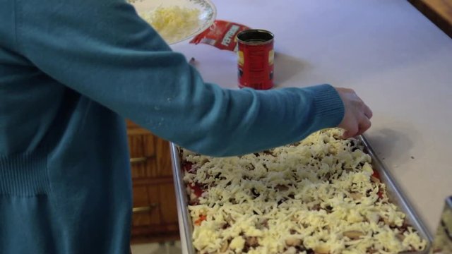 A Mennonite woman adds cheese to a homemade dish.