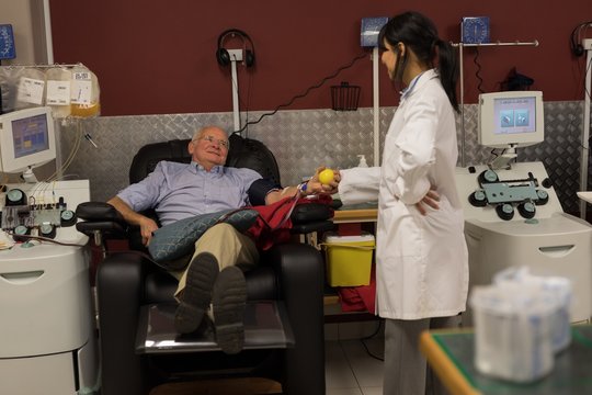 Senior man interacting with physician while donating blood