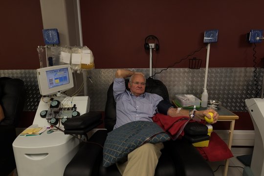 Senior man donating blood in blood bank