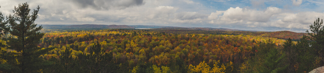wide panoramic view over Fall forest and lake with colorful trees from above in Algonquin Park,...