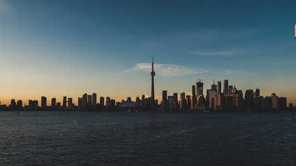 toronto skyline during sunset seen from toronto island with lake ontario infront